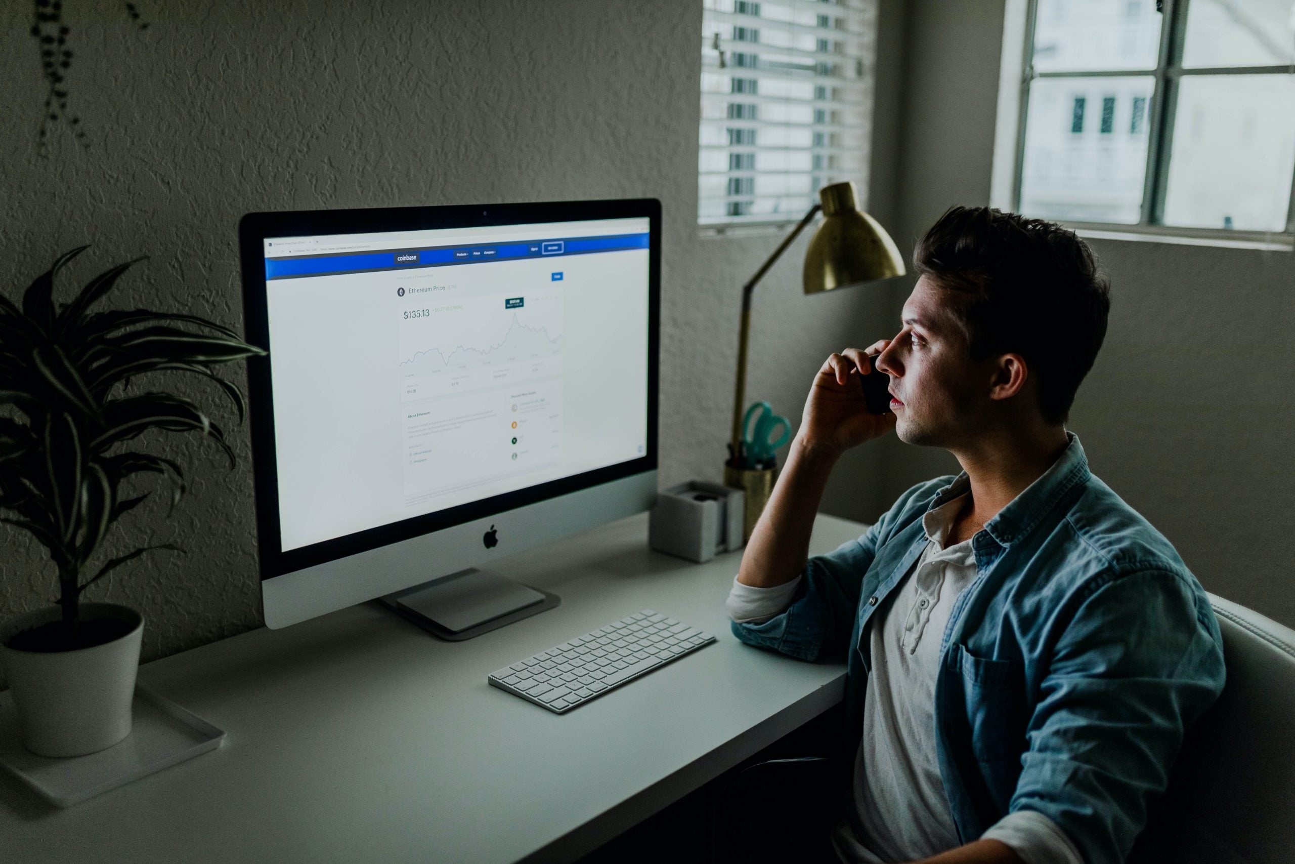 Man Talking on Phone at Desk Monitor